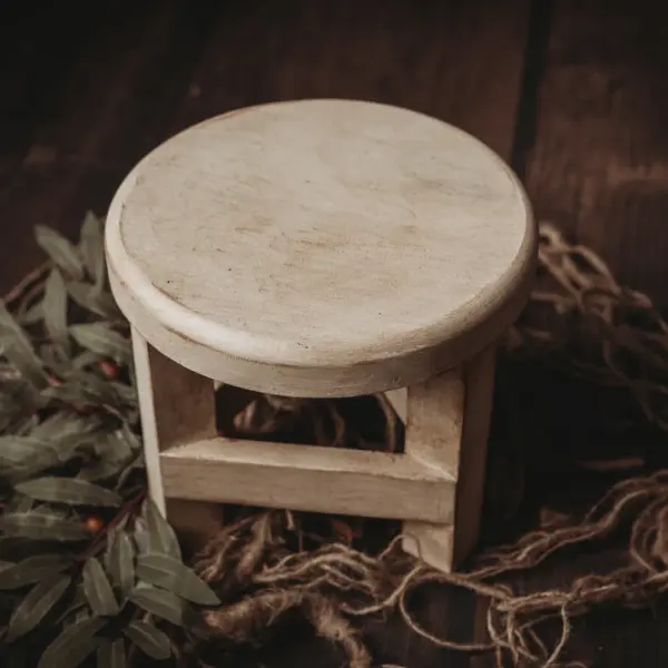 Round newborn sitter stool used for posed newborn photography in white