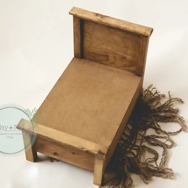 Wooden newborn photography bed used for posed newborn photography in natural